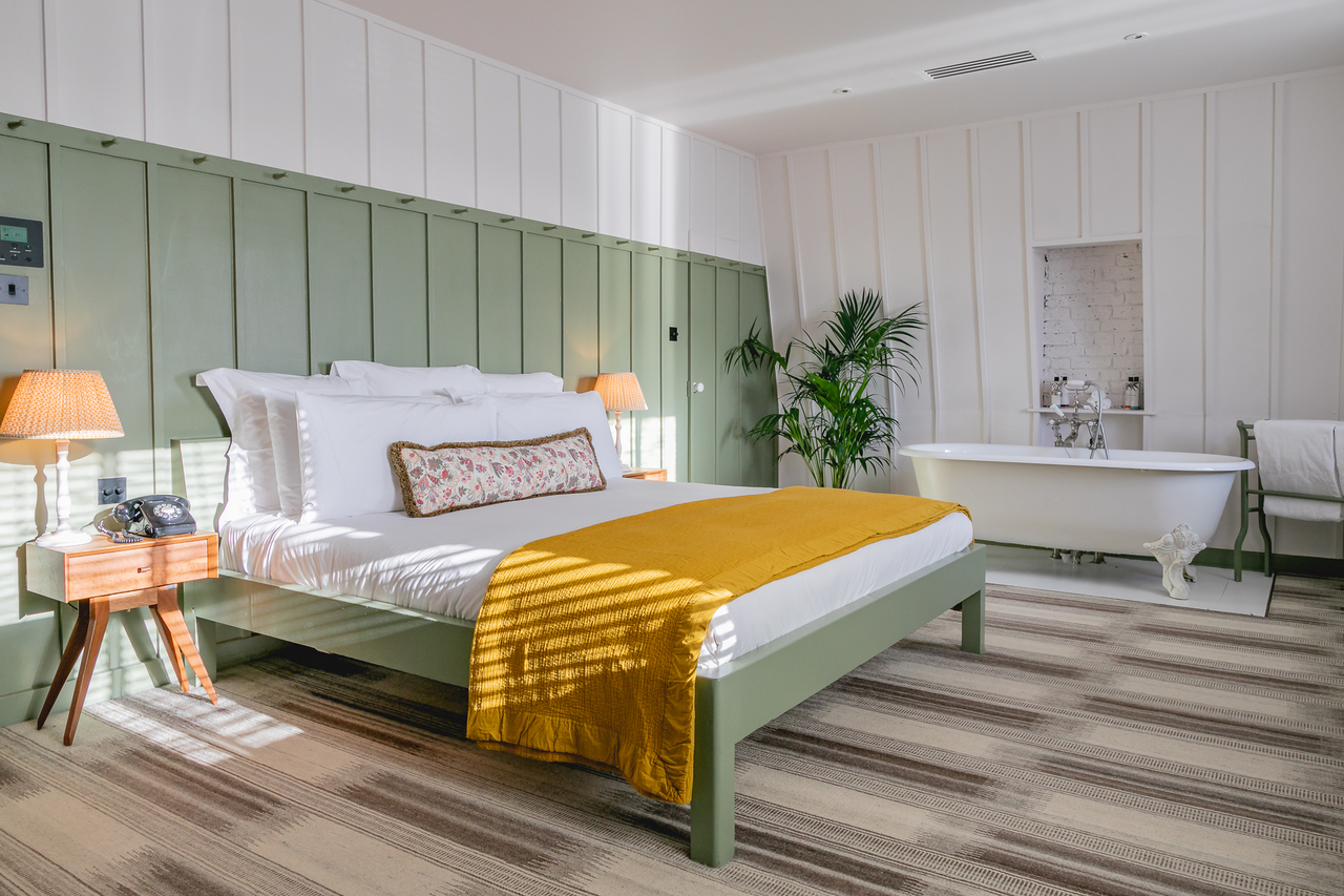 A large bedroom with light wood panelling